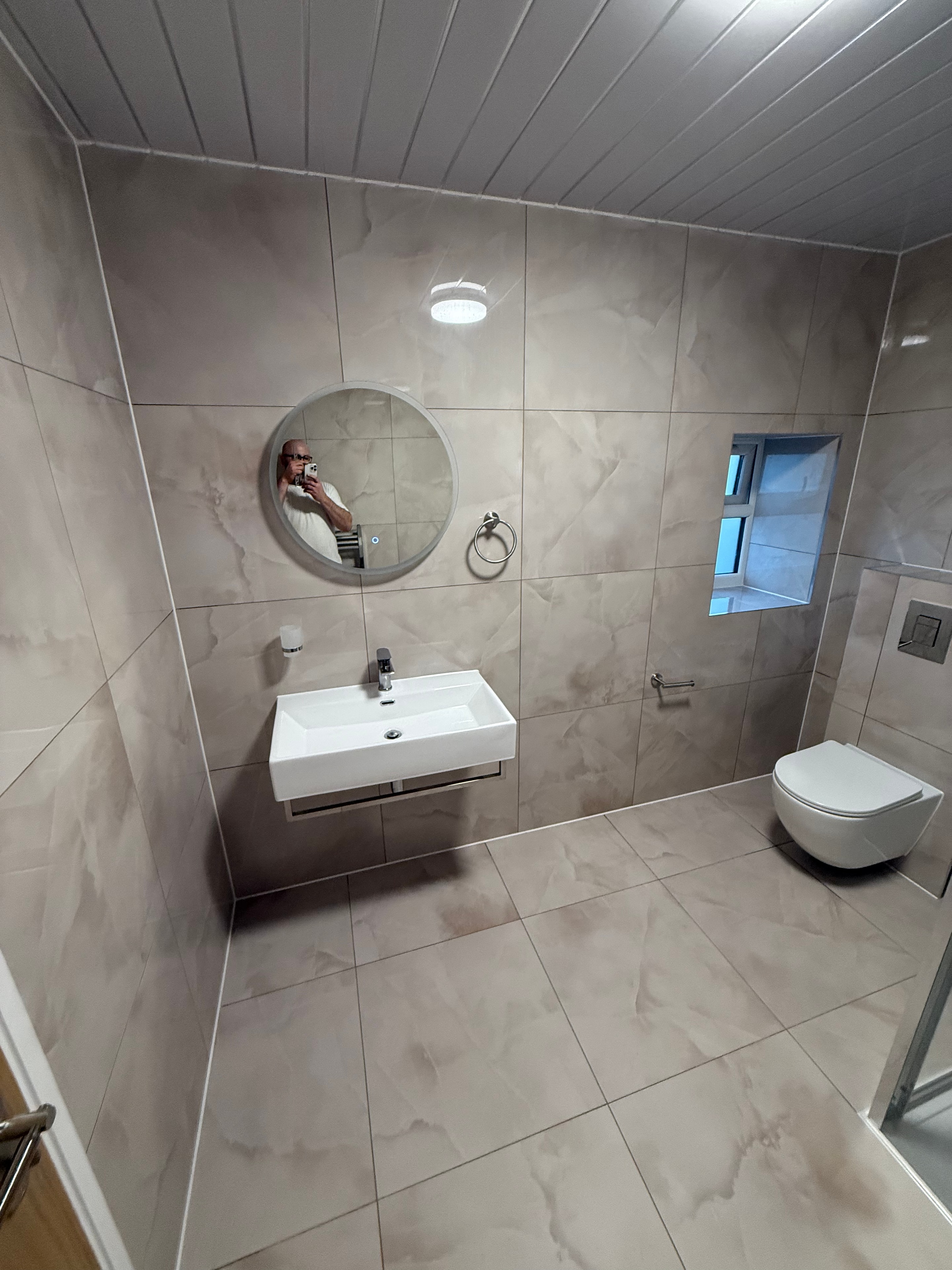 Completed bathroom renovation — finished room with dark bathtub and new fittings