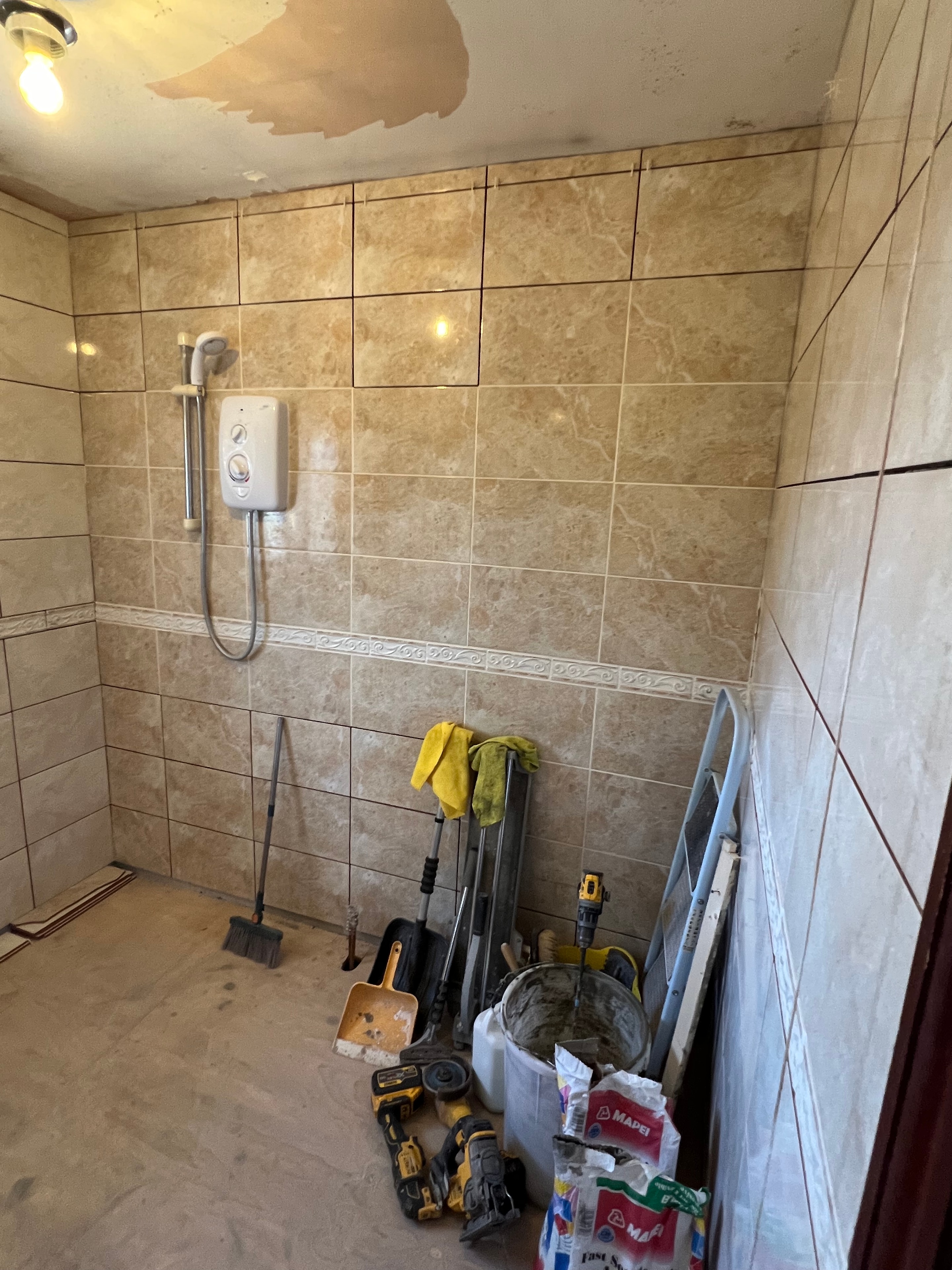 Bathroom during renovation — large-format tiling in progress with levelling spacers
