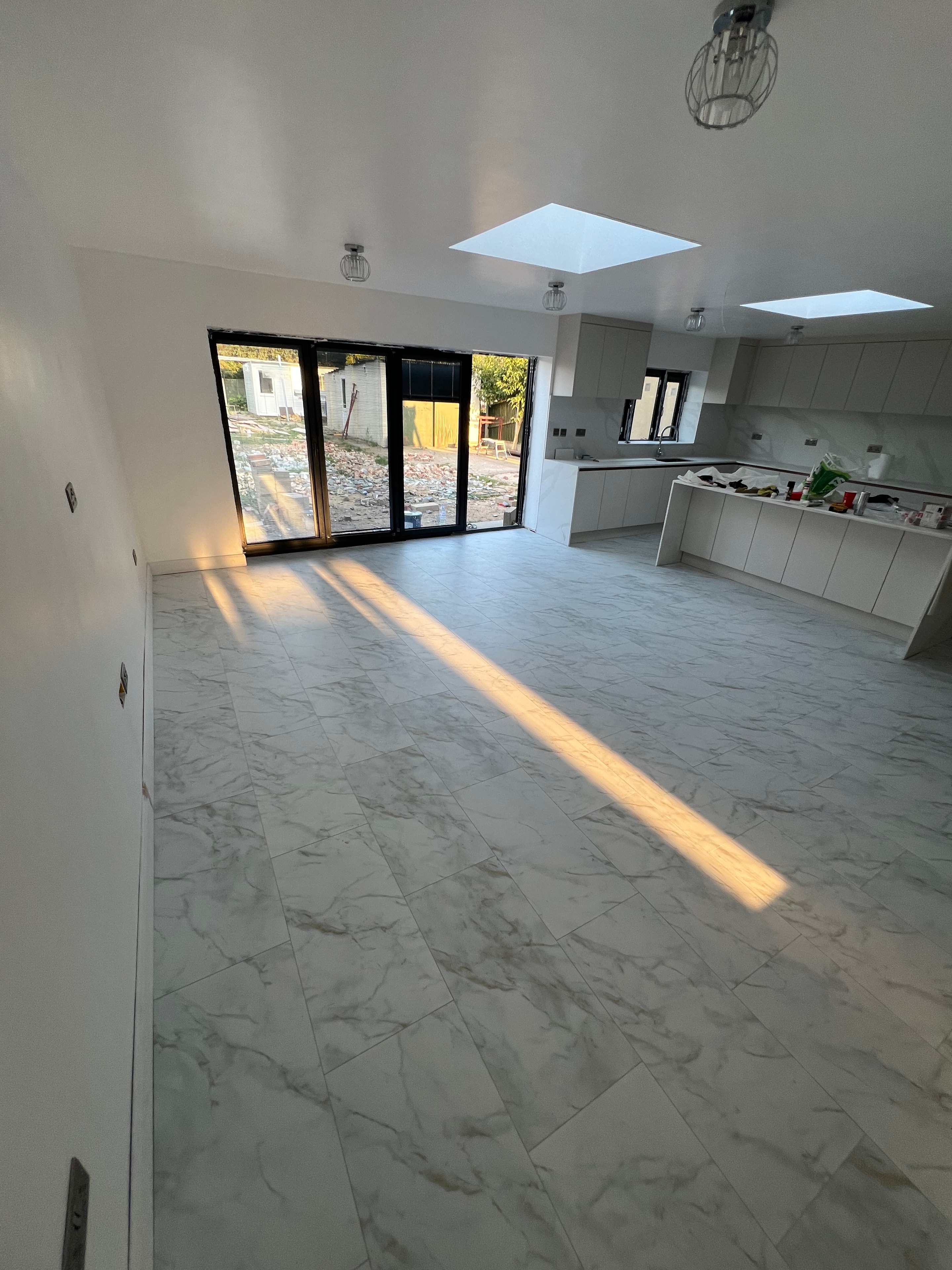 Kitchen during works — floor screed and tiling in progress
